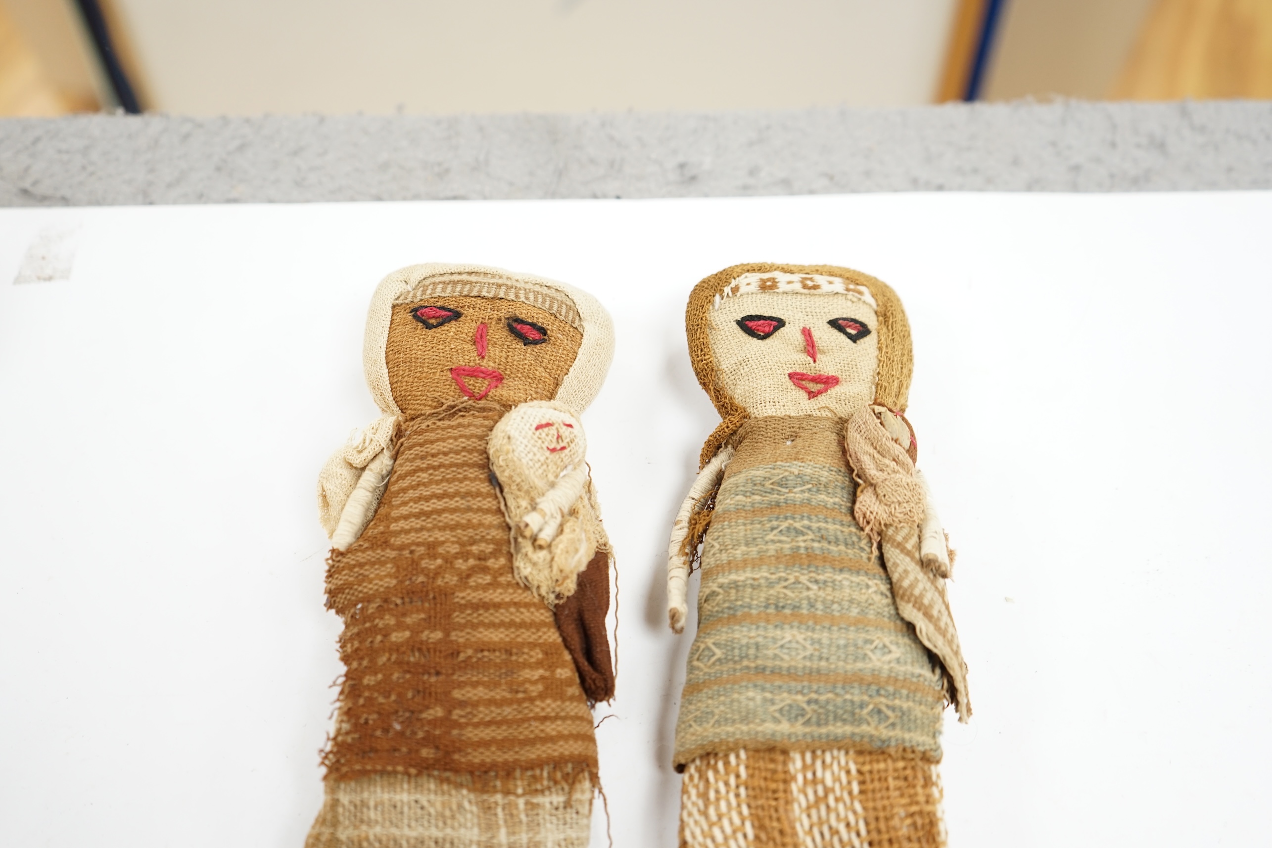 Two antique Chancay culture, central Peruvian hand made fabric dolls each carrying a baby. 25cm high. Condition - fair